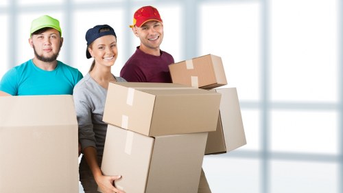 Removal team carrying office equipment during relocation