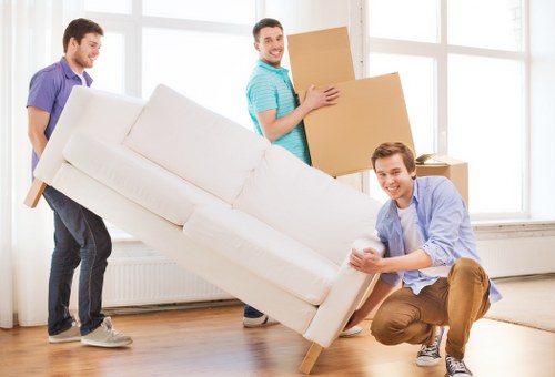 Removal workers loading furniture securely into a vehicle