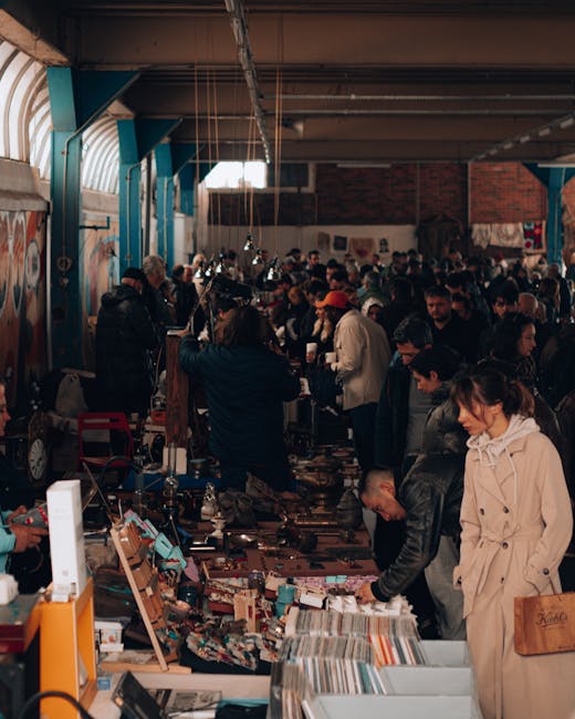 The image depicts a narrow workshop or storage area with a high, curved brick ceiling and a wooden floor. On the left side, a person wearing dark clothing is bent over, handling various items, possibl